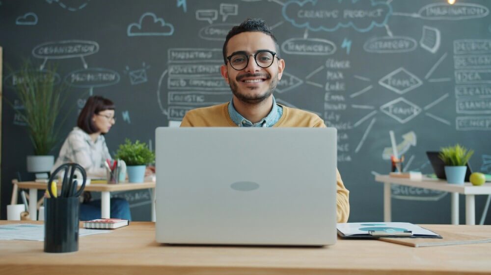 笑顔でノートパソコンを開く男性